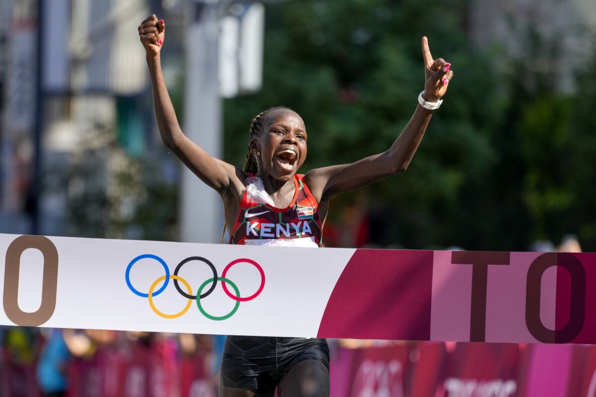 Peres Jepchirchir of Kenya celebrates as she crosses the finish line to win the Olympic women's marathon.