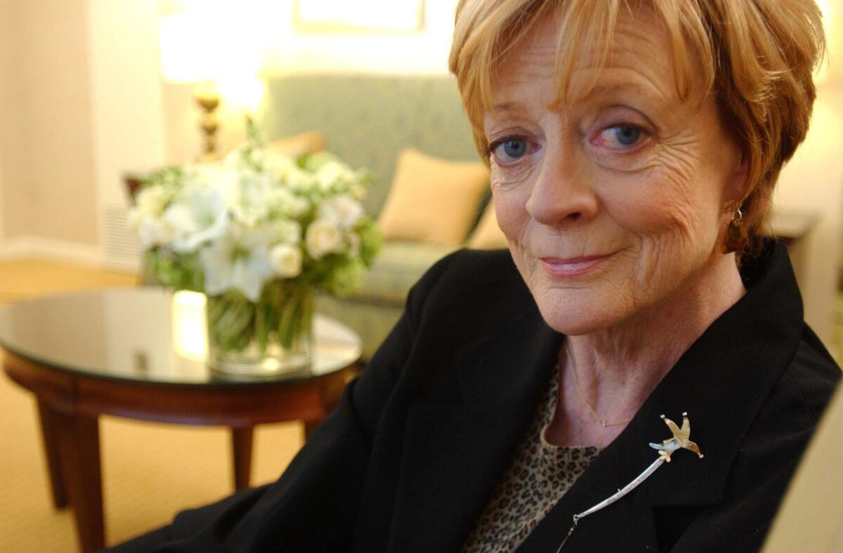 Close-up of Maggie Smith on a couch looking into the camera.