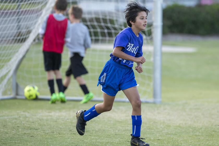 Newport Beach Carden Hall's Colin Jatwani scores a goal against Newport Beach Our Lady Queen of Angels in a boys' third- and fourth-grade Silver Division pool-play match at the Daily Pilot Cup at Jack R. Hammett Sports Complex in Costa Mesa on Thursday.