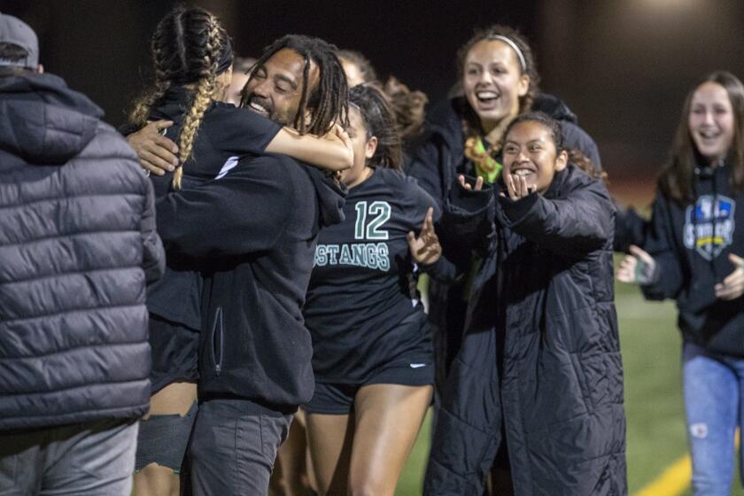 Costa Mesa's head coach Jason Boyce hugs Natalia Guzman after she scored the winning goal against Hillcrest's during quarterfinals match of the CIF Southern Section Division 5 on Tuesday, February 12.