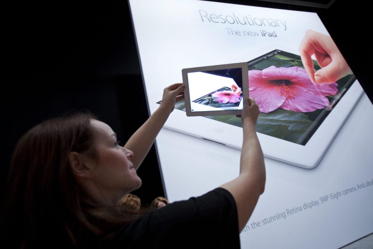 An Apple employee demos the camera on the new iPad in San Francisco. Rumors about an "iPad Mini" are again gaining traction.