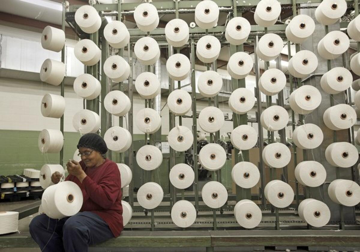 Wal-Mart announced a $10-million fund to spur U.S. manufacturing. Above, a worker in Georgia checks spools of yarn that will be woven into towels that will be sold at Wal-Mart.