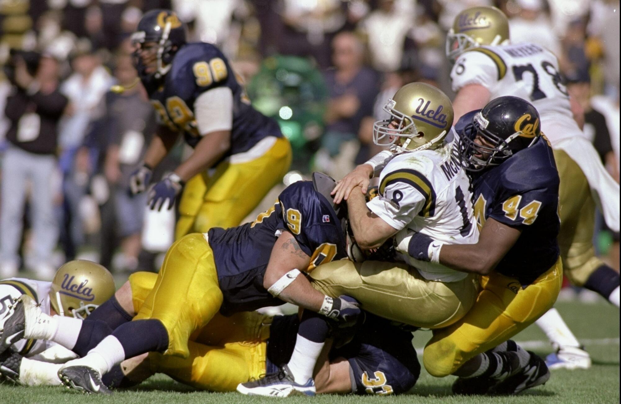 UCLA quarterback Cade McNown is tackled by Cal's Albert Dorsey and Nate Geldermann on Oct. 24, 1998.