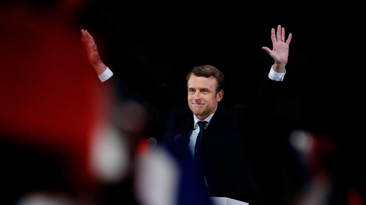 French President-elect Emmanuel Macron waves to a crowd of supporters outside the Louvre Museum in Paris on May 7, 2017.
