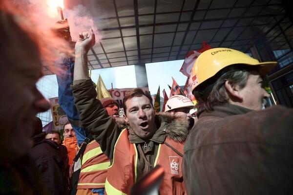 Employees of French oil company Total SA demonstrate at its headquarters in La Defense, outside Paris after the company announced it will close its Dunkirk refinery. The decision has prompted strikes and some violence as workers oppose the move.