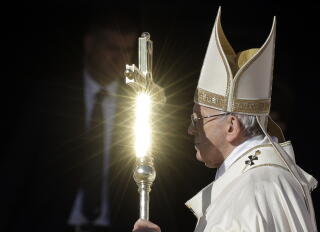 Pope Francis' pastoral staff is hit by a ray of the sun as he carries it outdoors.