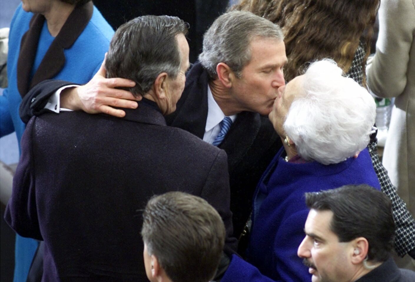 President George W. Bush gives his mother, Barbara, a kiss as his father watches at the U.S. Capitol after inauguration ceremonies on Jan. 20, 2001.
