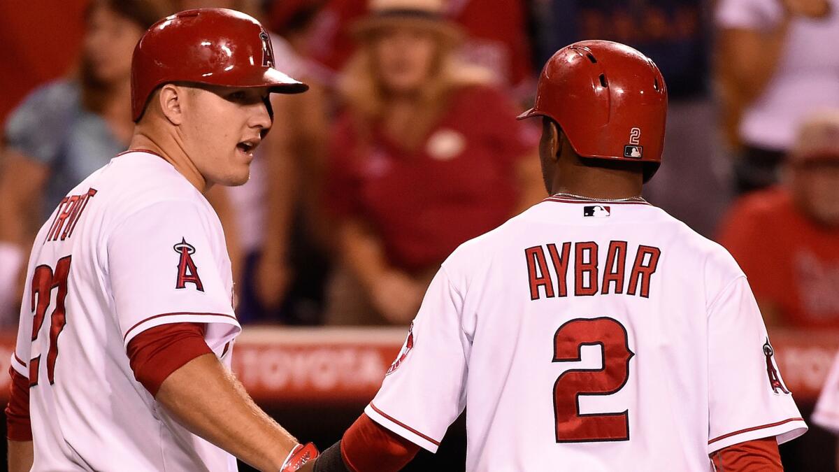 Angels shortstop Erick Aybar, right, is congratulated by teammate Mike Trout after scoring in the eighth inning of the team's 3-2 win over the Baltimore Orioles on July 23.