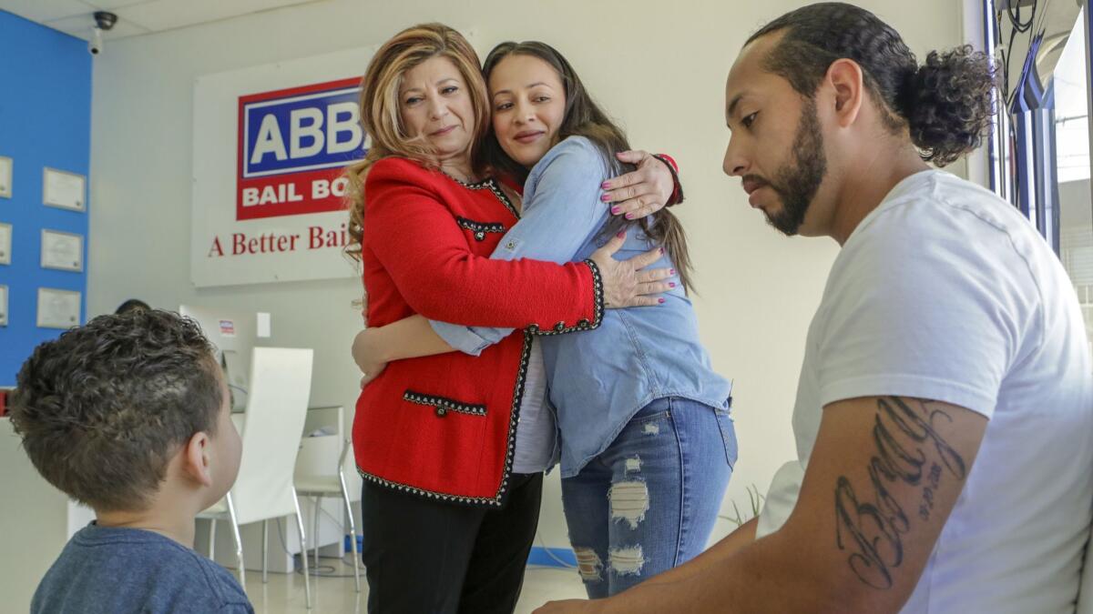 Jorge Garcia, 26, with wife Claudia Abarca and 2-year-old son Jaasiel Garcia, visits Jane Un, center left, who helped him make bail.