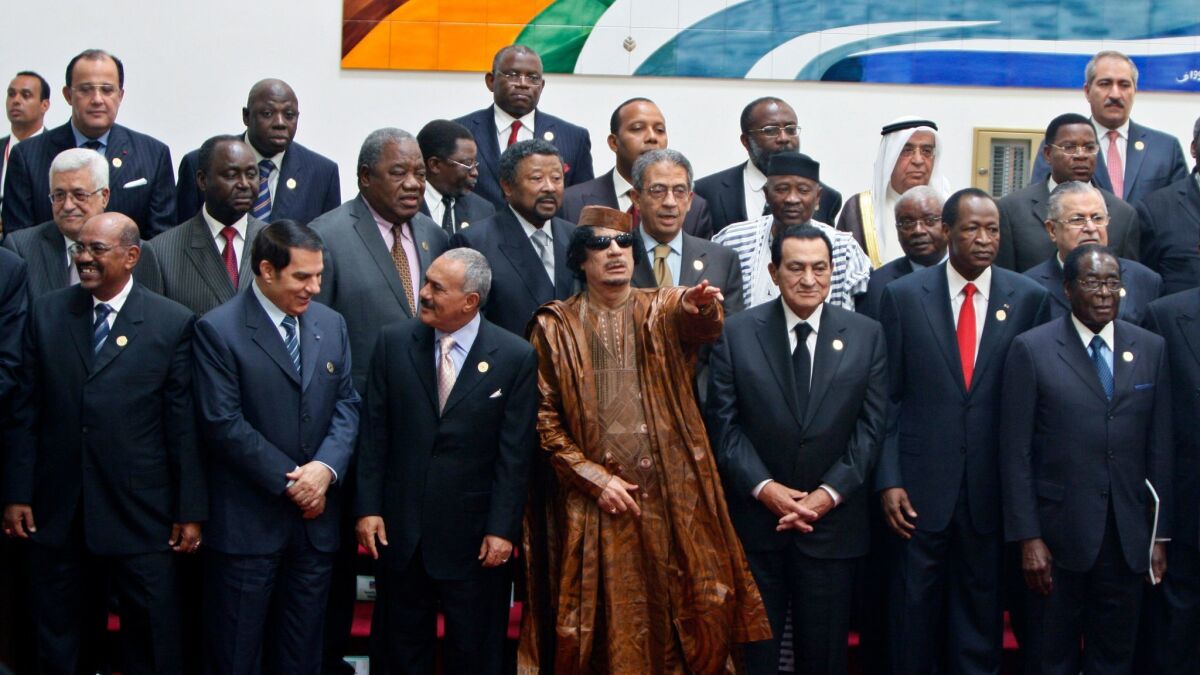 Libyan leader Moammar Kadafi, center, gestures during a group picture with Arab and African leaders during the second Afro-Arab summit in Sirte, Libya, on Oct. 10, 2010.