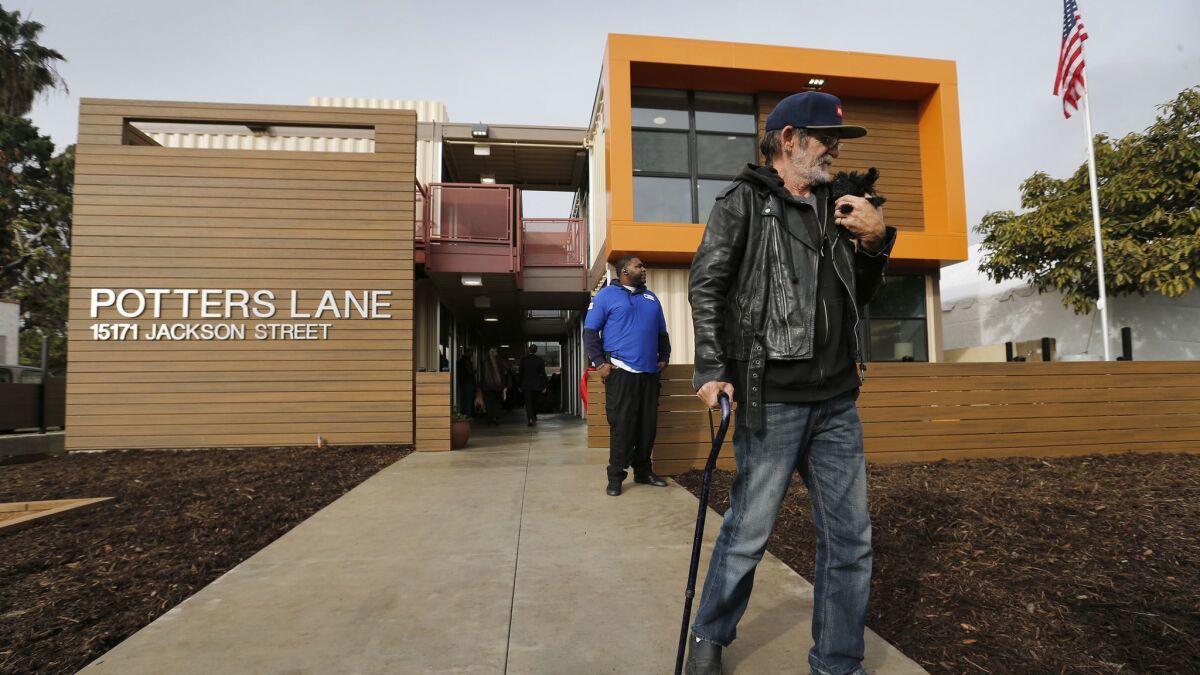 Homeless Army veteran Jimmy Palmiter, 59, holds his dog while touring his future home in 2017 during the grand opening of Potter's Lane, the nation's first multi-family housing development built with recycled shipping containers.