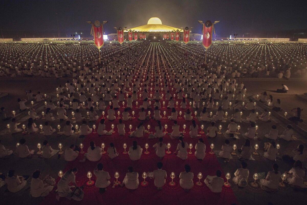 Buddhists sit beside candles during a ceremony at the Dhammakaya Temple in Bangkok on Feb. 22, 2016 on the occasion of Makha Bucha day.