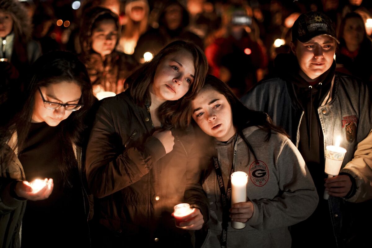 FILE - Caprice Cortez, Faith Goodsell, Autumn Barton and Mykaylla Darrow, all teammates on the Grantsville High School girls soccer team that Alexis Haynie played on, stand together at a candlelight vigil for the Haynie family at City Park in Grantsville, Utah, on Jan. 20, 2020. Colin "CJ" Haynie pleaded guilty Tuesday, July 19, 2022, to killing his mother and three siblings when he was a teenager in 2020. (Spenser Heaps/The Deseret News via AP, File)