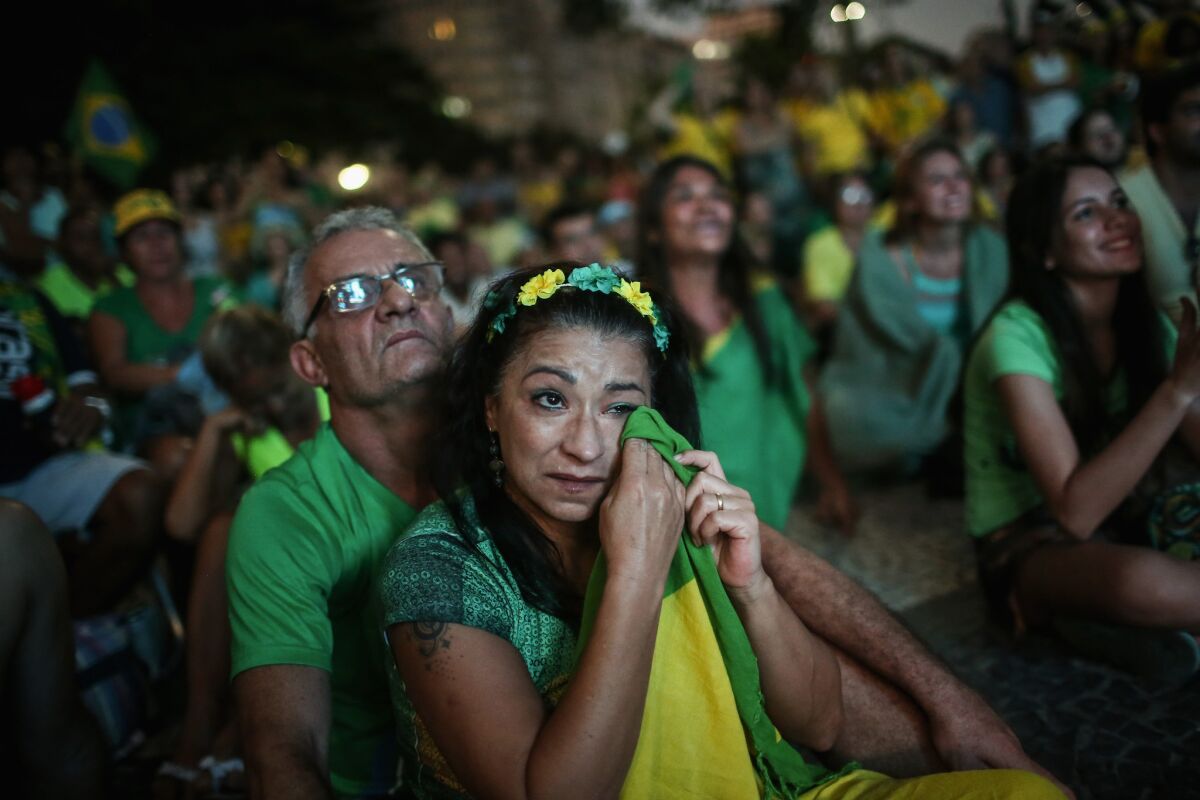 A pro-impeachment supporter wipes a tear with her Brazilian flag while watching a live television broadcast as lower house deputies voted to impeach President Dilma Rousseff on April 17, 2016.