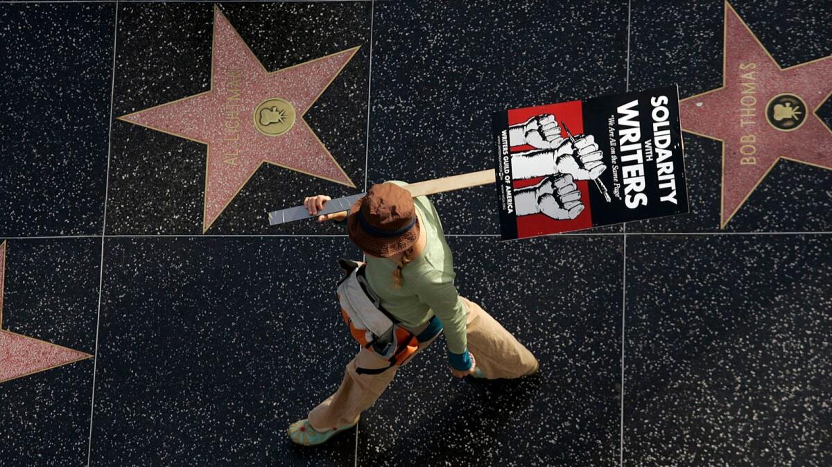 A picketer walks along the Walk of Fame on Hollywood Boulevard in 2007 during the Writers Guild of America strike that lasted 100 days.