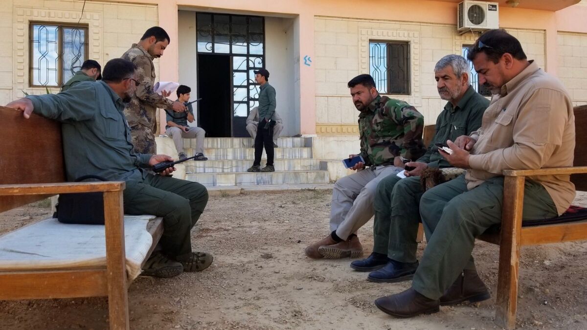 Hajj Qassem Musleh, far right, a commander in the Iraqi paramilitary forces, coordinates with an Iranian advisor sitting beside him before embarking on the day's patrol.