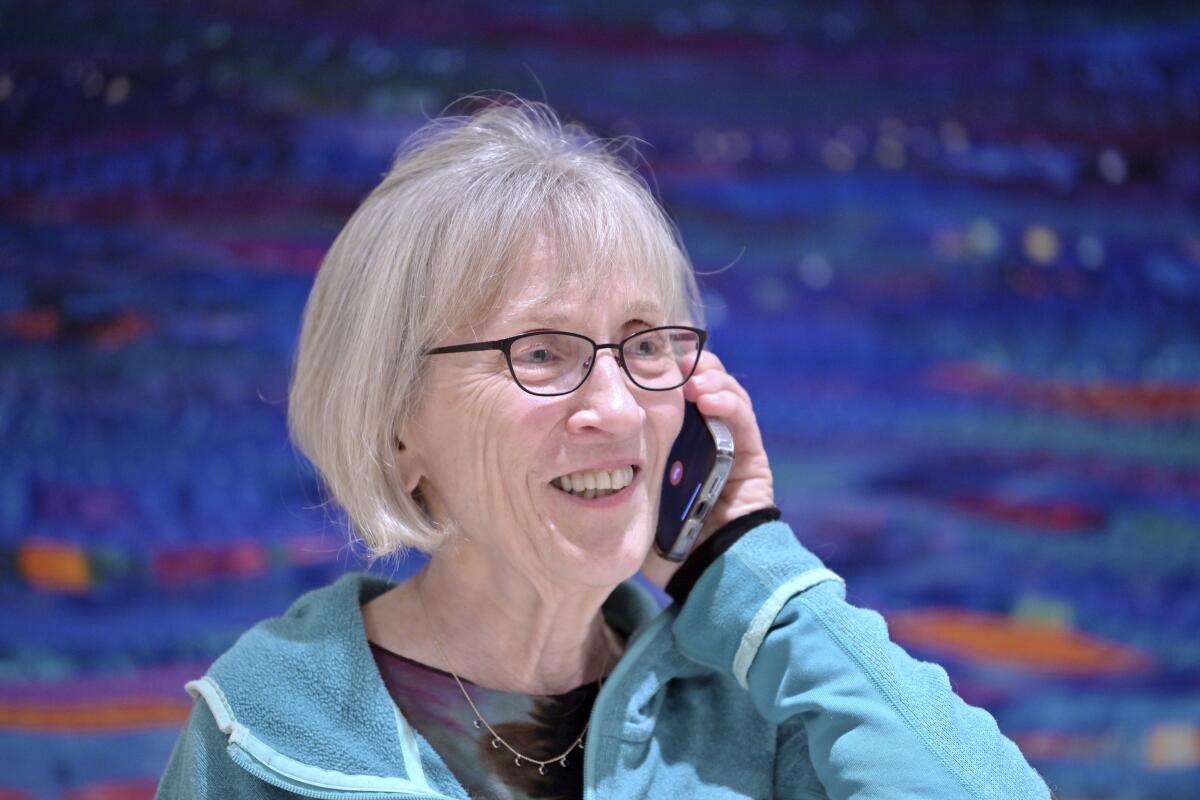 A smiling woman talks on a mobile phone. 