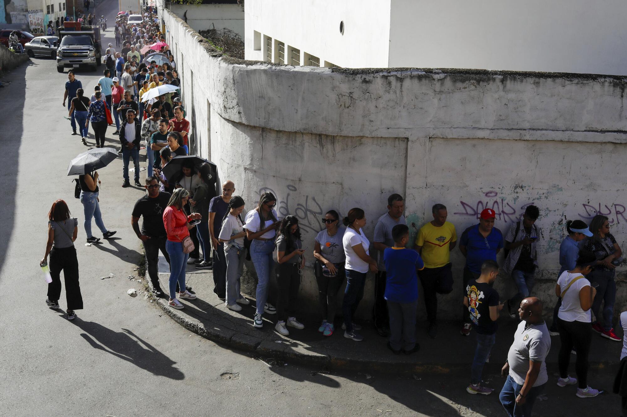 Los votantes hacen fila afuera de un centro de votación durante las elecciones 