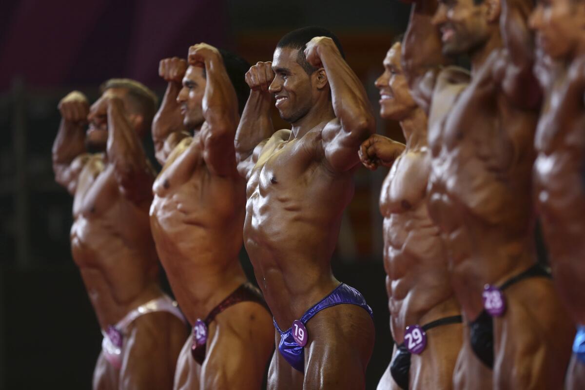 Los competidores por las primeras medallas oficiales en la historia del fisicoculturismo en los Juegos Panamericanos muestran sus músculos en Lima, el sábado 10 de agosto de 2019 (AP Foto/Rodrigo Abd) ** Usable by HOY, ELSENT and SD Only **