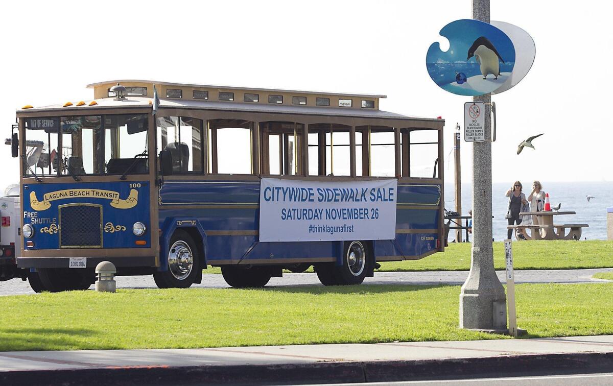 A Laguna Beach trolley with banner advertising this weekend’s citywide sidewalk sale parked at Main Beach.