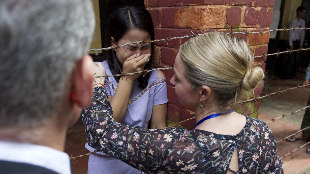 Chit Su Win, center, wife of Reuters journalist Kyaw Soe Oo, is comforted by a Reuters official on Sept. 3, 2018, in Yangon, Myanmar.