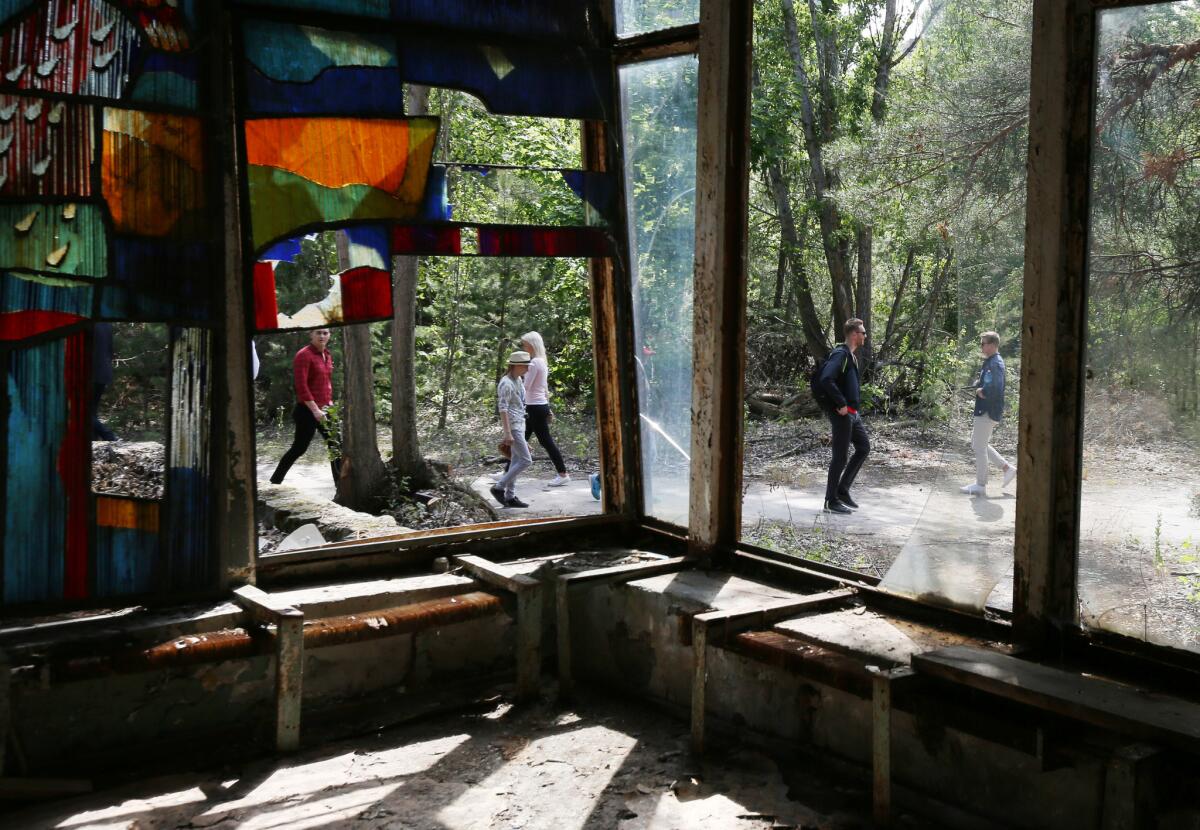 Foreign tourists walk through the abandoned town of Pripyat in the Chernobyl Exclusion Zone.