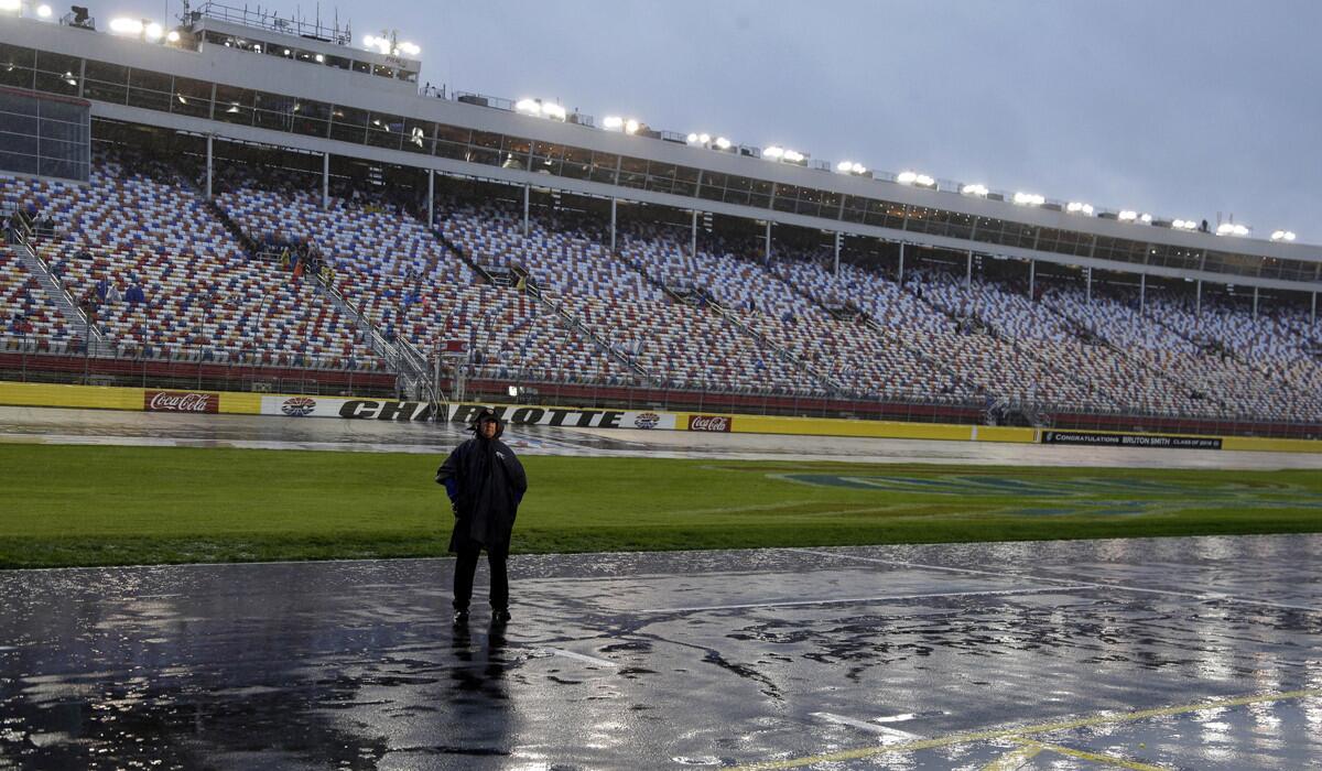 A security guard stands in the pouring rain on pit road before the scheduled start of the NASCAR Sprint Cup series auto race at Charlotte Motor Speedway in Concord, N.C. on Saturday.