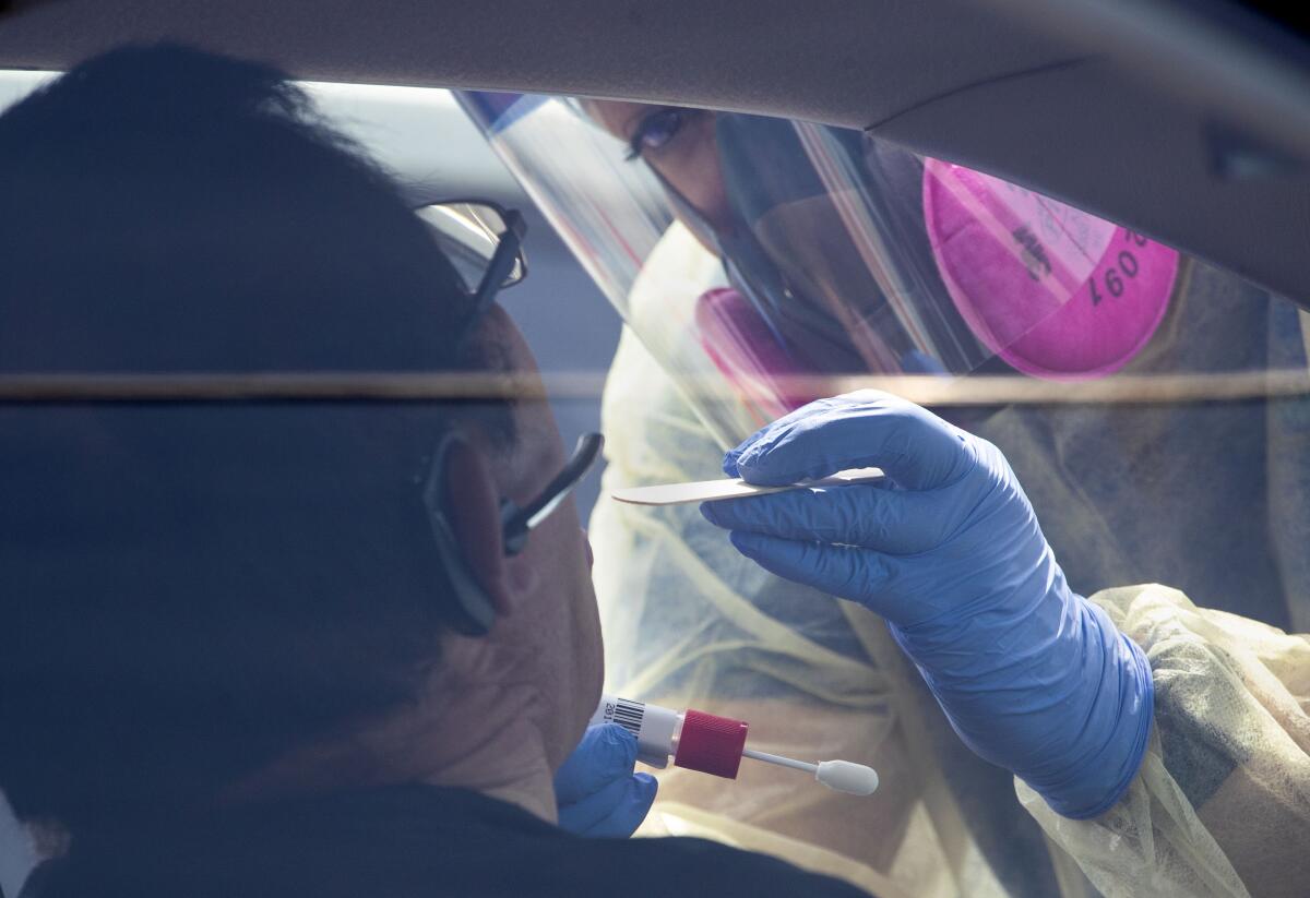 An AltaMed Health Services staffer swabs a patient during COVID-19 testing in Boyle Heights.