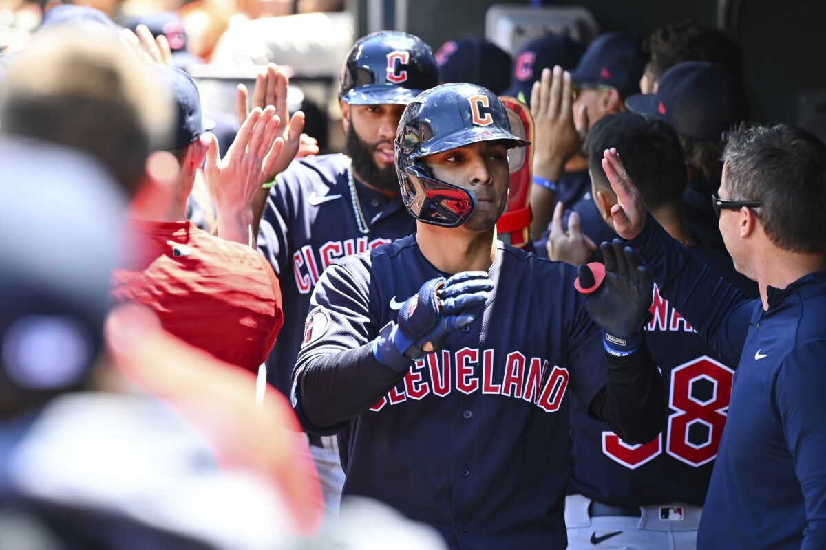 Cleveland Guardians' Andres Gimenez is greeted by teammates after hitting a three-run home run against Baltimore Orioles starting pitcher Dean Kremer during the first inning of a baseball game, Sunday, June 5, 2022, in Baltimore. (AP Photo/Terrance Williams)