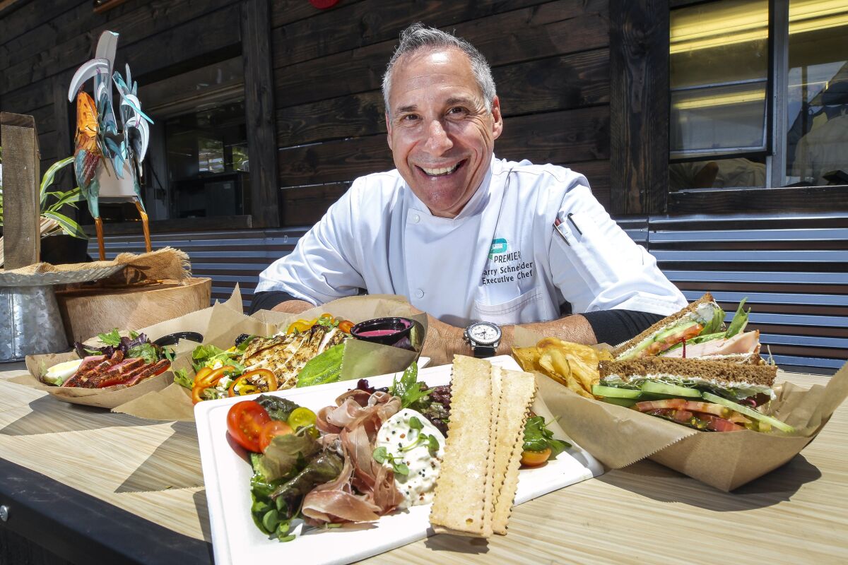 Barry Schneider, executive chef for the Del Mar Fairgrounds' Premiere Food Services, displays several dishes on the menu at the new Emerald Farms Eatery, in the garden area, at the San Diego County Fair, which opens its summer run on Friday, May 31.
