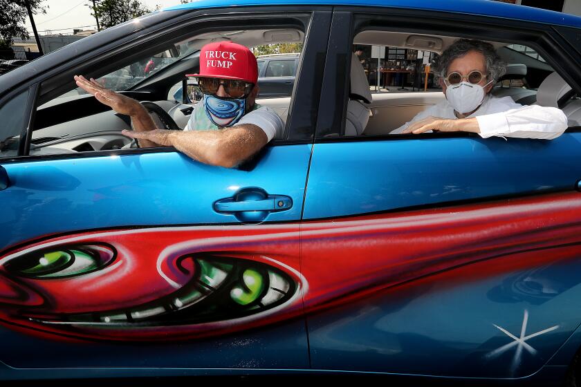 LOS ANGELES, CA - SEPT. 26, 2020. Artist Kenny Scharf and gallery owner Jeffrey Deitch sit in Scharf's painted car, which was part of a caravan featuring Scharf's nobile artworks on Saturday, Sept. 26, 2020. The event kicked off an installation of Scharf's work at the Jeffrey Deitch Gallery in L.A., patt of which includes Scharf's 2013 project of painted vehicles. A Los Angeles native, Scharf is best known for his work in the East Village art scene of New York in the 1980s. (Luis Sinco / Los Angeles Times)