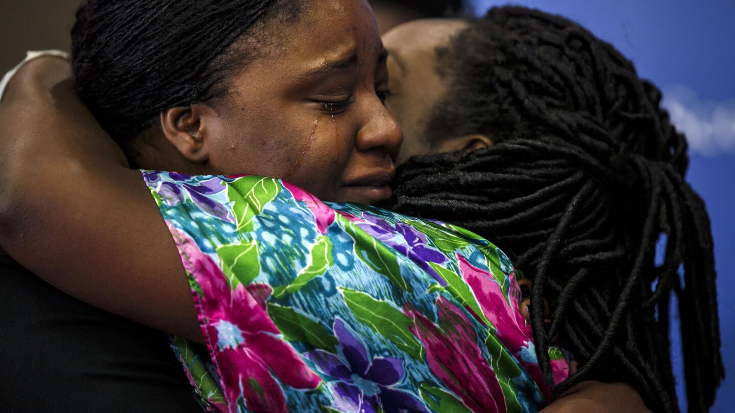 Shetamia Taylor, right, who is recovering after being shot, hugs Angie Wisner, who helped save her son during the deadly attack when a gunman killed five police officers and wounded other officers and civilians in Dallas during a peaceful protest.