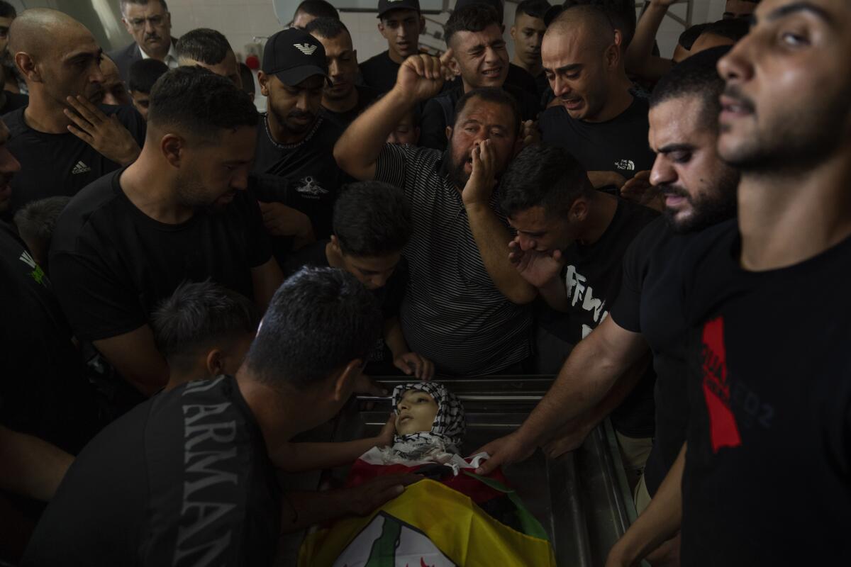 Mourners chant anti-Israel slogans while they take the last look at the body of Fares Abu Samra, 14, during his funeral.