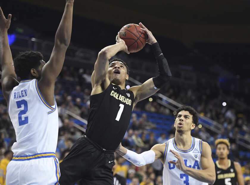 Colorado guard Tyler Bey shoots between UCLA forward Cody Riley, left, and guard Jules Bernard during the first half on Thursday at Pauley Pavilion.