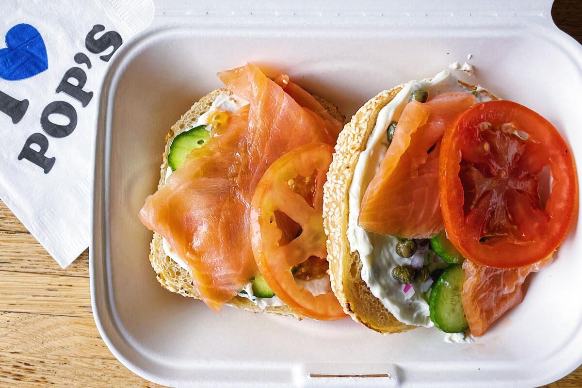 An overhead photo of an open-faced Pop's Bagels lox sandwich with tomato and cucumber from the Fairfax Pop's Bagels.