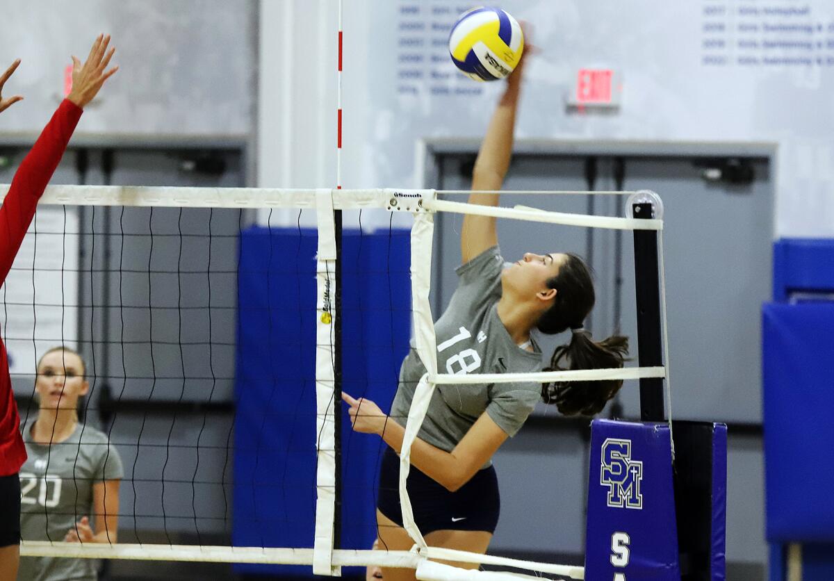 Newport Harbor's Anabel Kotzakov (18) spikes the ball against Orange Lutheran in the Trinity-Sunset League Showcase.