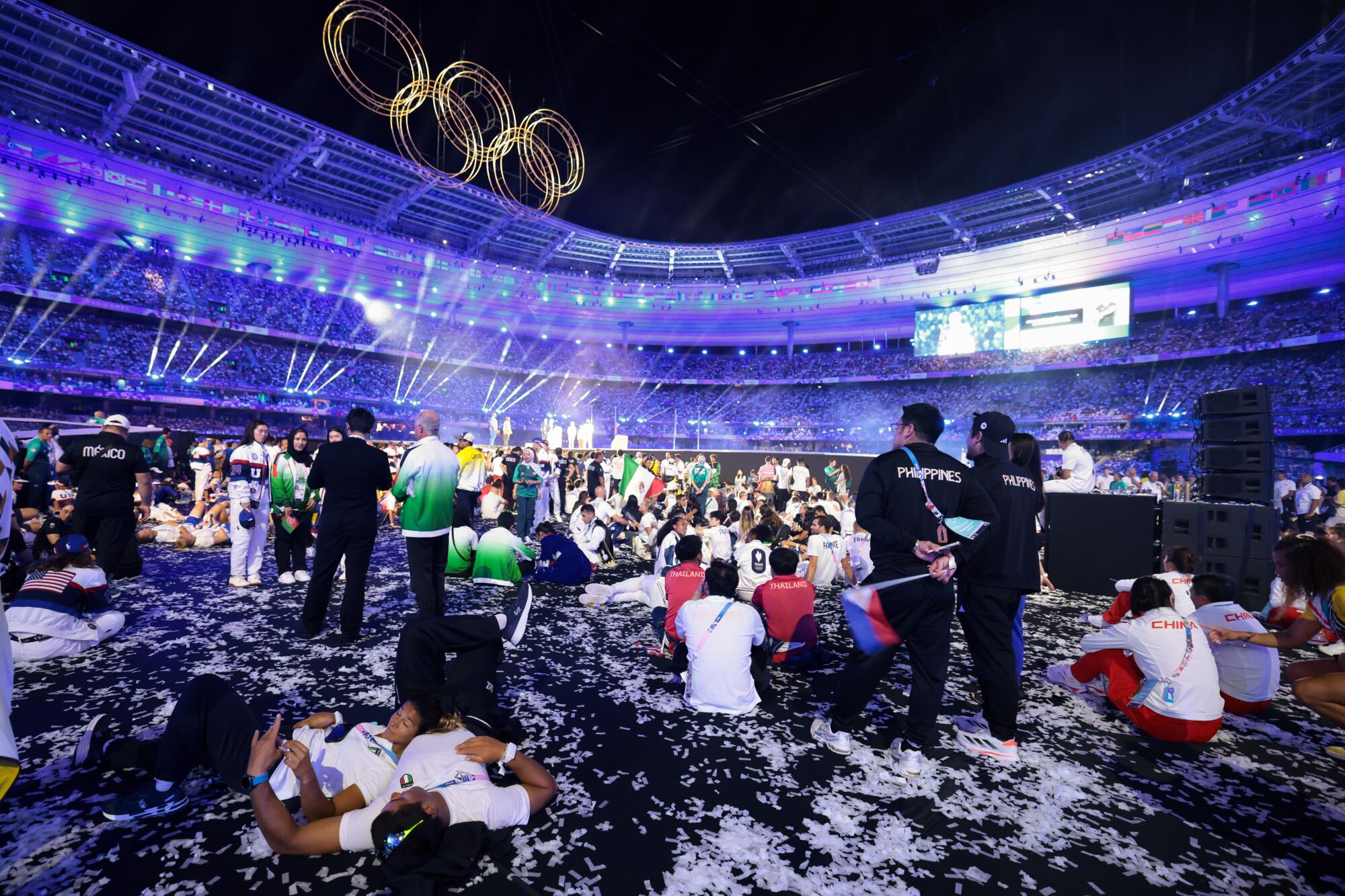 Athletes watch from the side of the stage during the closing ceremony.