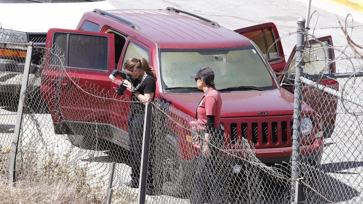 Investigators take photographs near a vehicle in Burbank where police found three dead bodies on Tuesday, April 17. Coroner's officials have confirmed two of the victims died of gunshot wounds to the head.