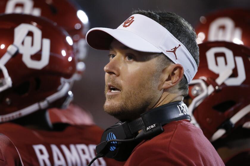 Oklahoma head coach Lincoln Riley talks with players 