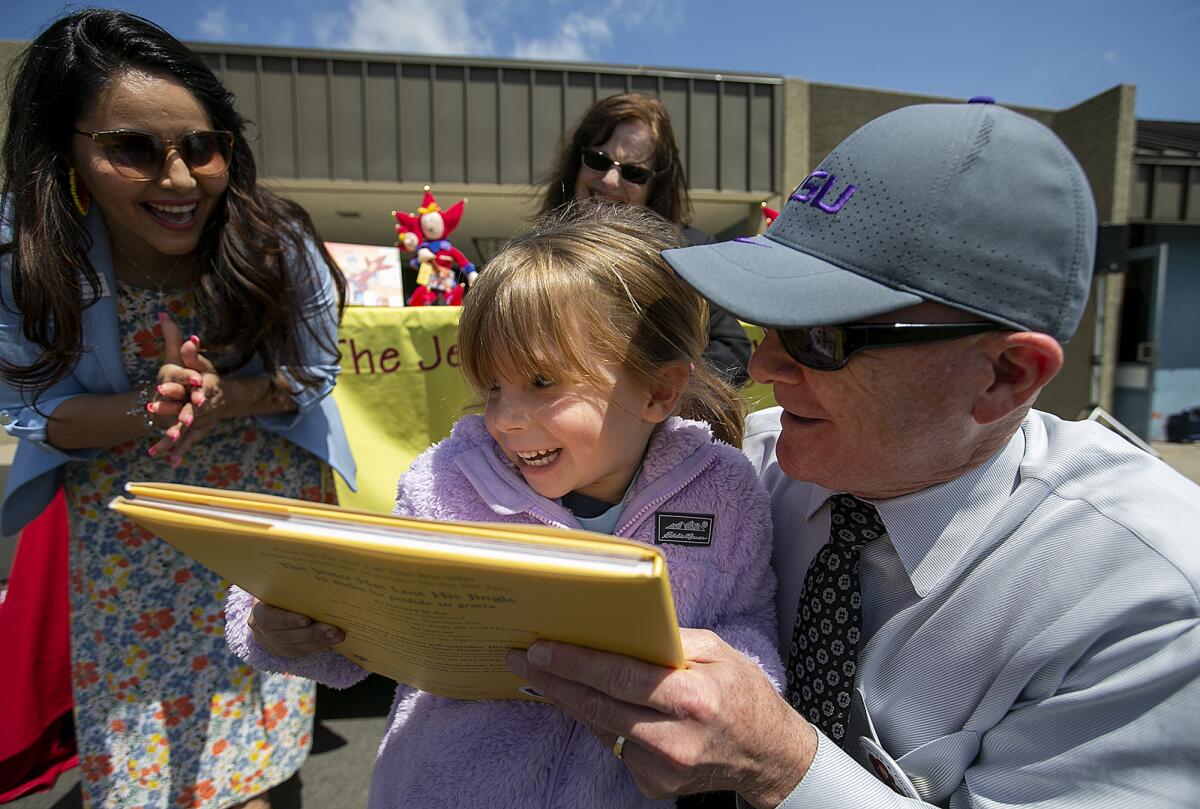 June Salazar, a transitional kindergartner at Golden View Elementary, receives a copy of "The Jester Has Lost His Jingle."