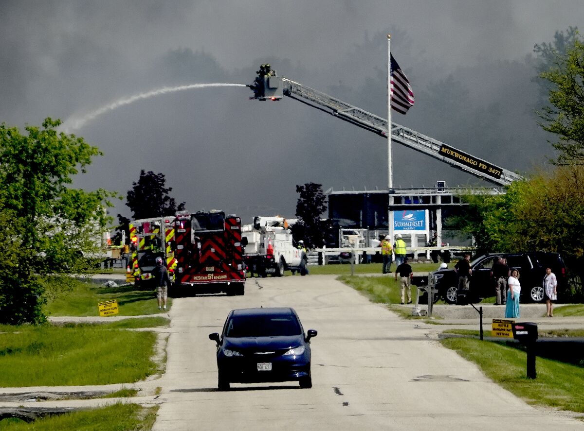 Emergency crews work to extinguish a fire at Summerset Marine Construction in Eagle, Wis., on Thursday, May 19, 2022. Six people were hurt, including three firefighters, when an explosion and fire rocked the marine construction company in southeast Wisconsin on Thursday. (Mike De Sisti /Milwaukee Journal-Sentinel via AP)