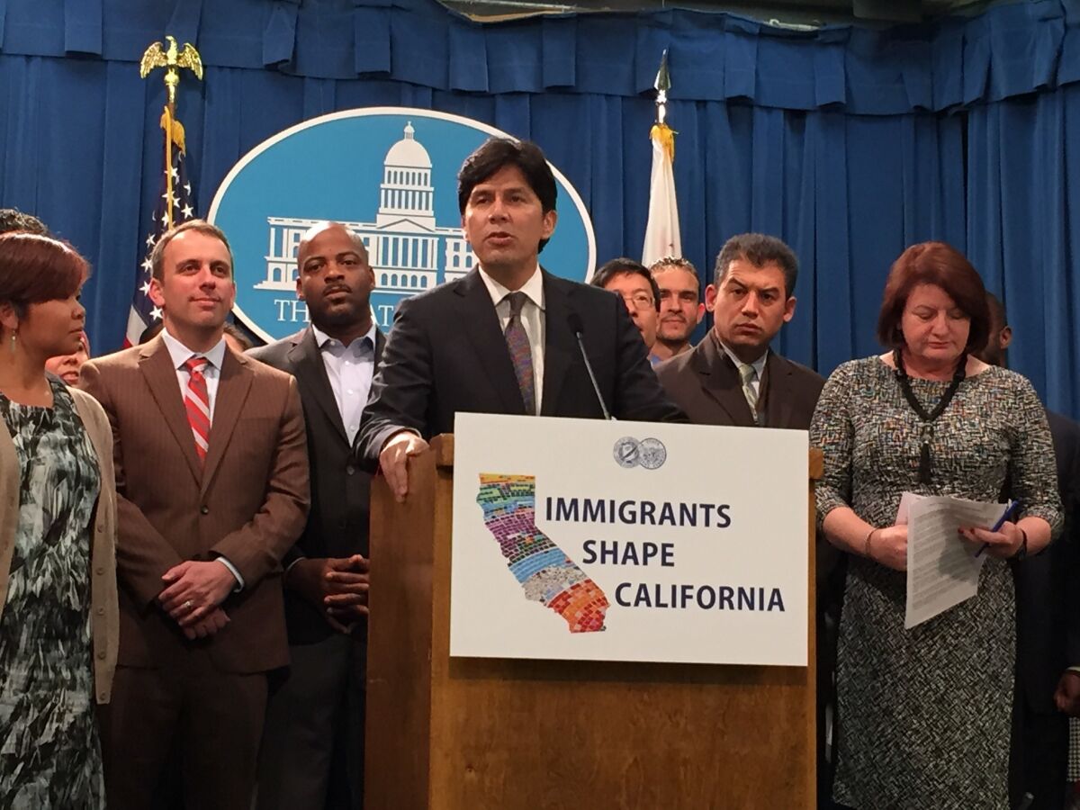 Senate Pro Tem Kevin de Leon, at lectern, and Assembly Speaker Toni Atkins, right, unveiled a package of 10 immigration bills at the state Capitol on Tuesday.