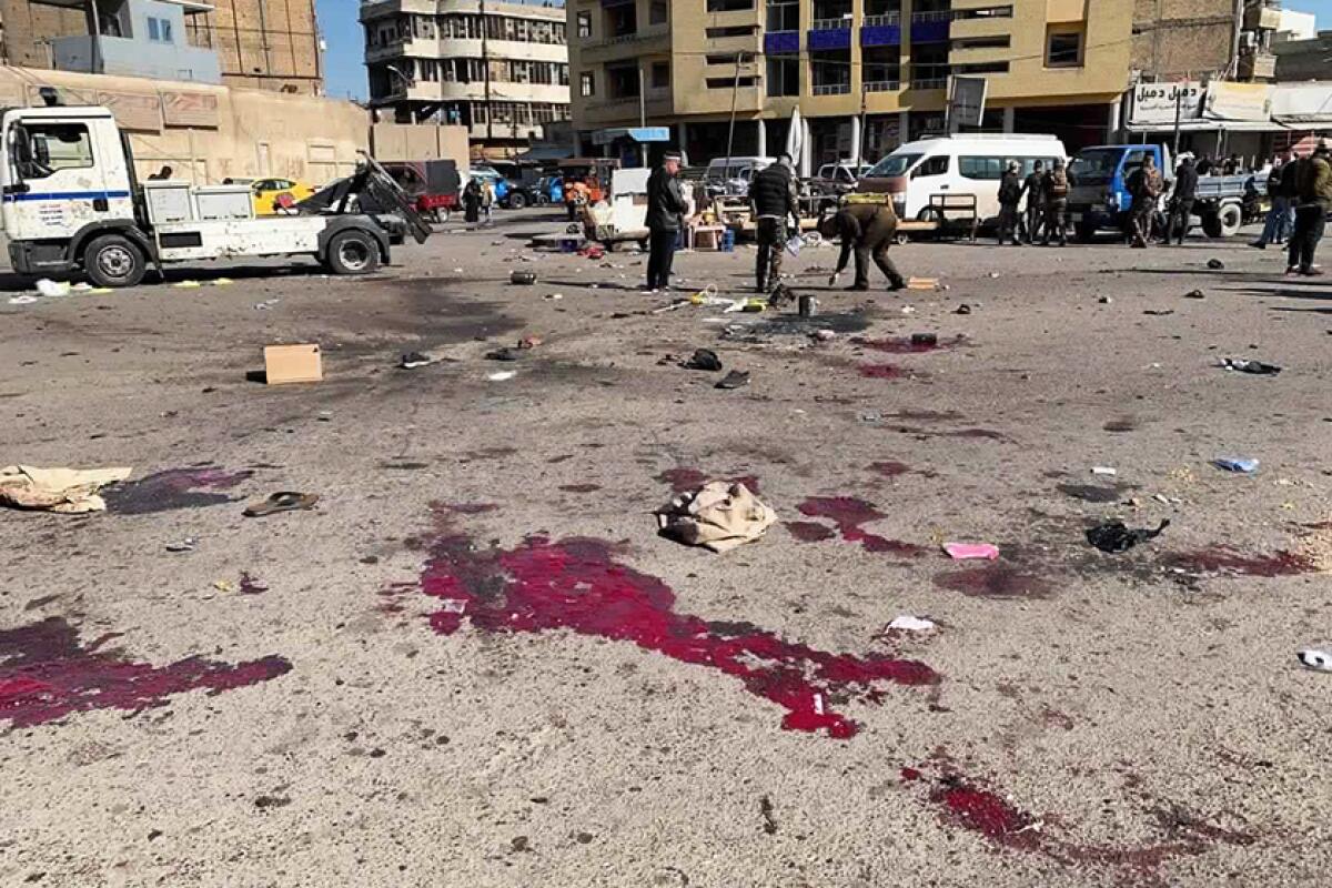 Iraqi security forces examine the site of a deadly bomb attack in Baghdad on Jan. 21, 2021.