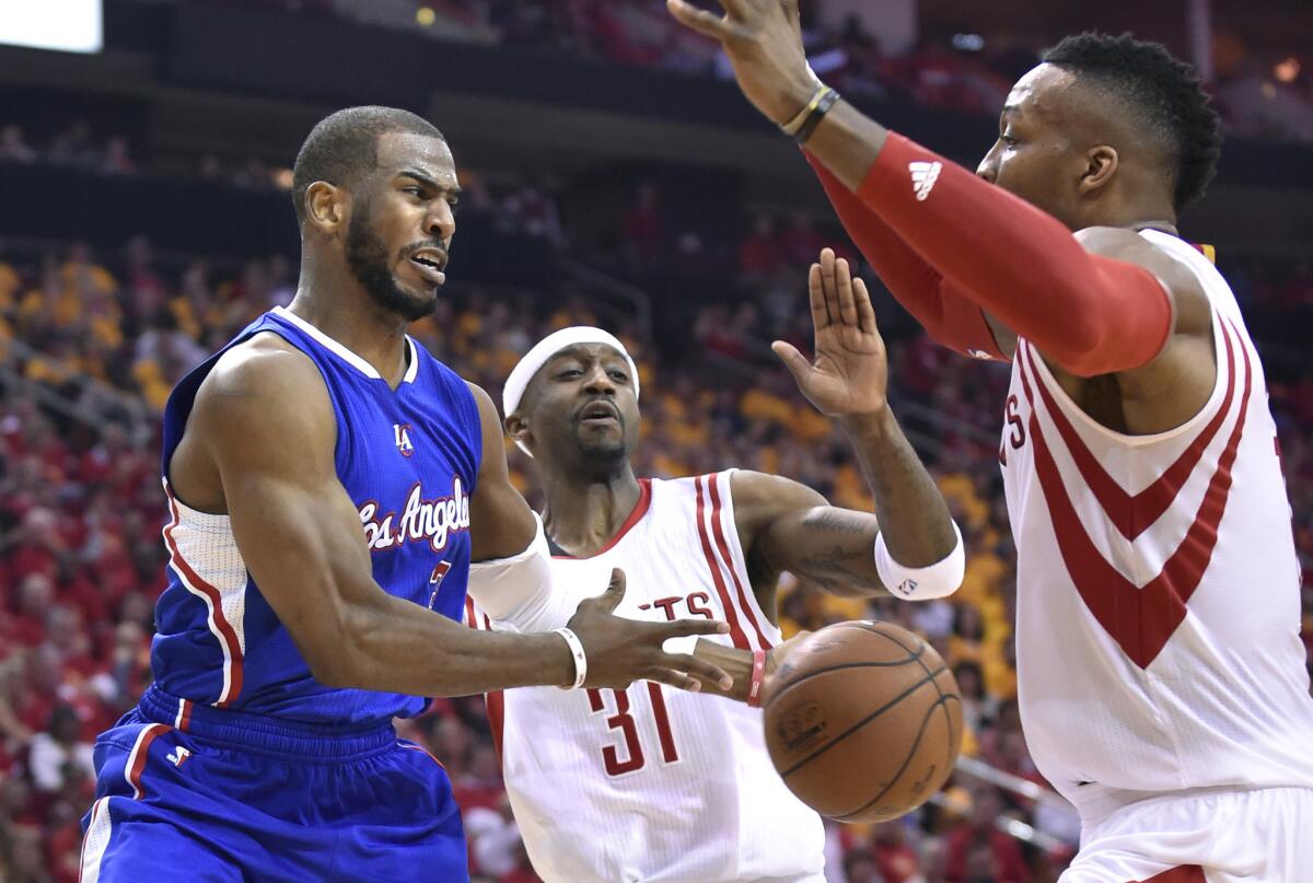 Chris Paul gets a pass off in front of Houston's Dwight Howard, right, and Jason Terry during the Clippers' Game 5 loss Tuesday to the Rockets, 124-103.