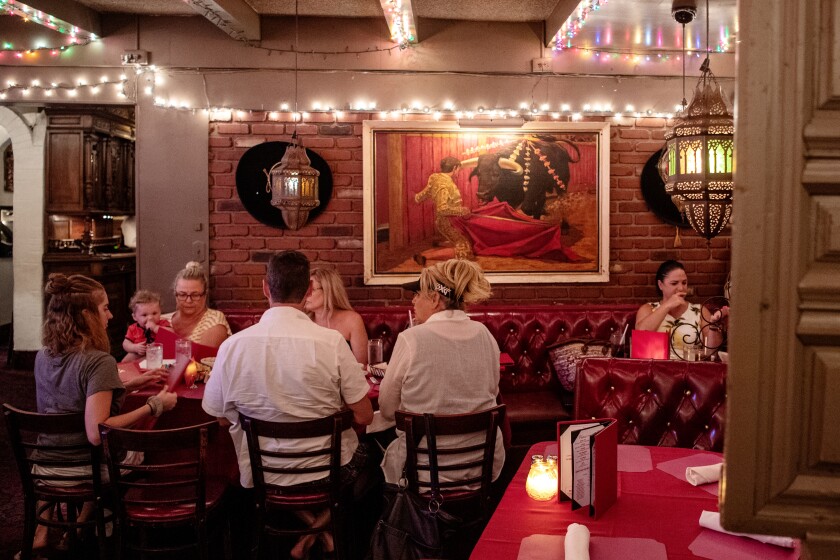 Ein Foto von Gästen, die 2019 drinnen an roten Sitznischen im Casa Vega speisen.