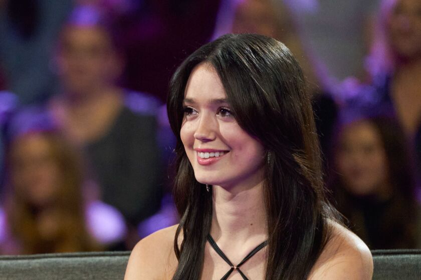 Woman, Greer Blitzer, a contestant on season 27 of "The Bachelor" smiling while seated in black dress and dark brown hair