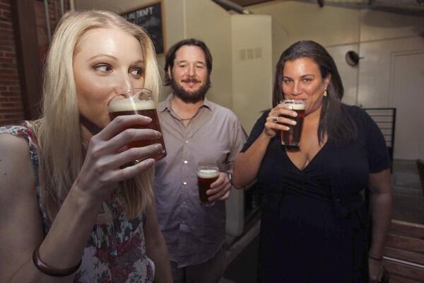 Hallie Beaune, left, her boyfriend Matthew Testa and Christina Perozzi enjoy a beer at the "What a Pair!" event at the Library Alehouse in Santa Monica.