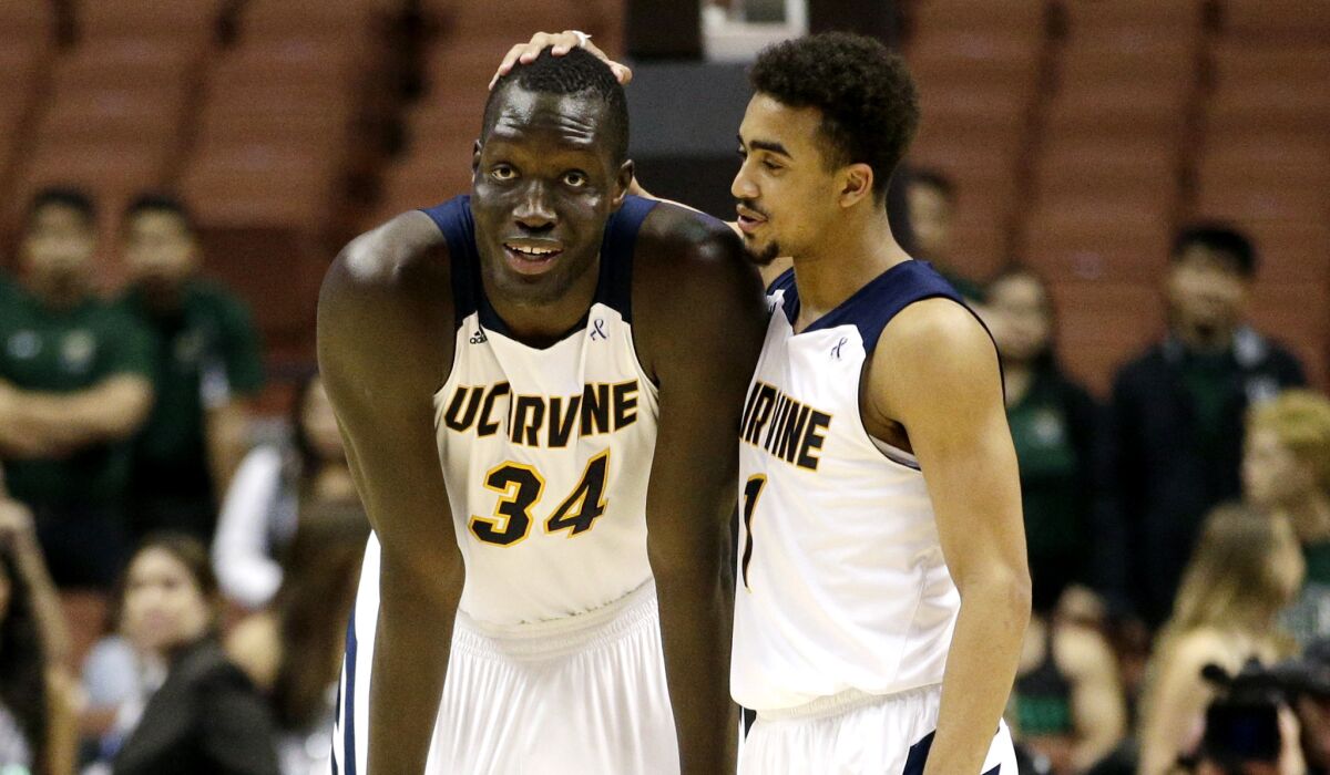 UC Irvine guard Alex Young chats with center Mamadou Ndiaye (34) during a break in play against Hawaii in the Big West Conference tournament championship game.