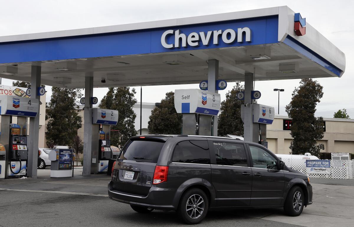 A motorist drives near the pumps at a Chevron gas station