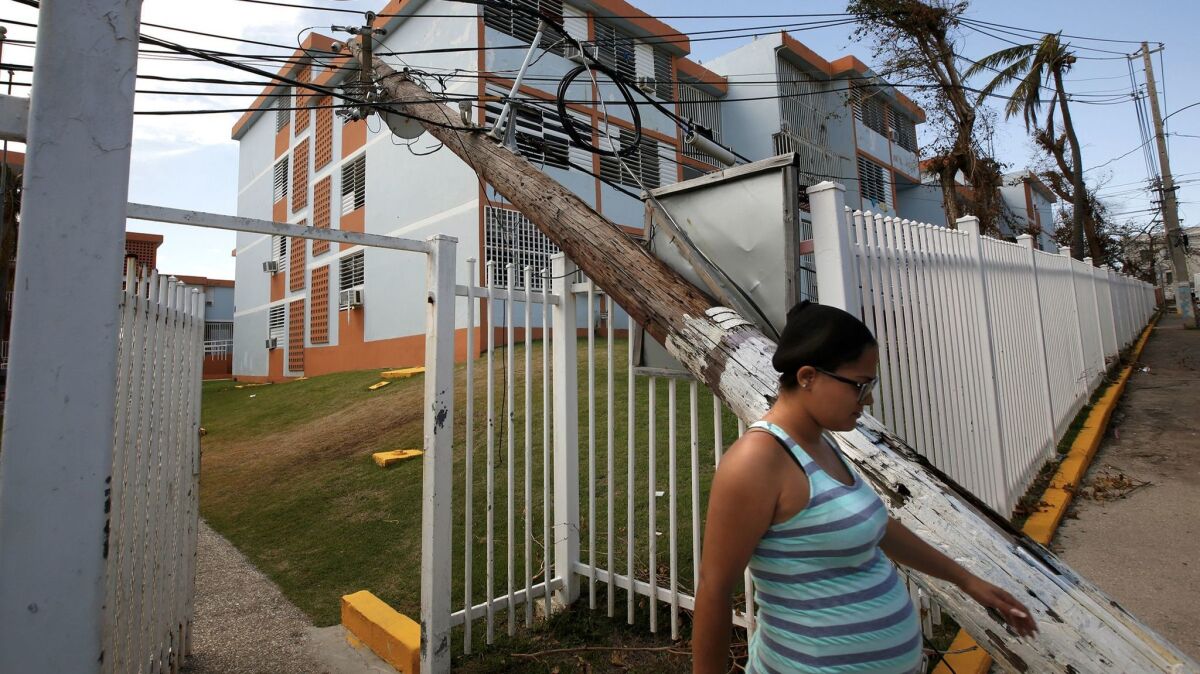 In downtown San Juan, electric lines lie in the road and poles block apartment complexes, like the Residencia Parque San Lorenzo.